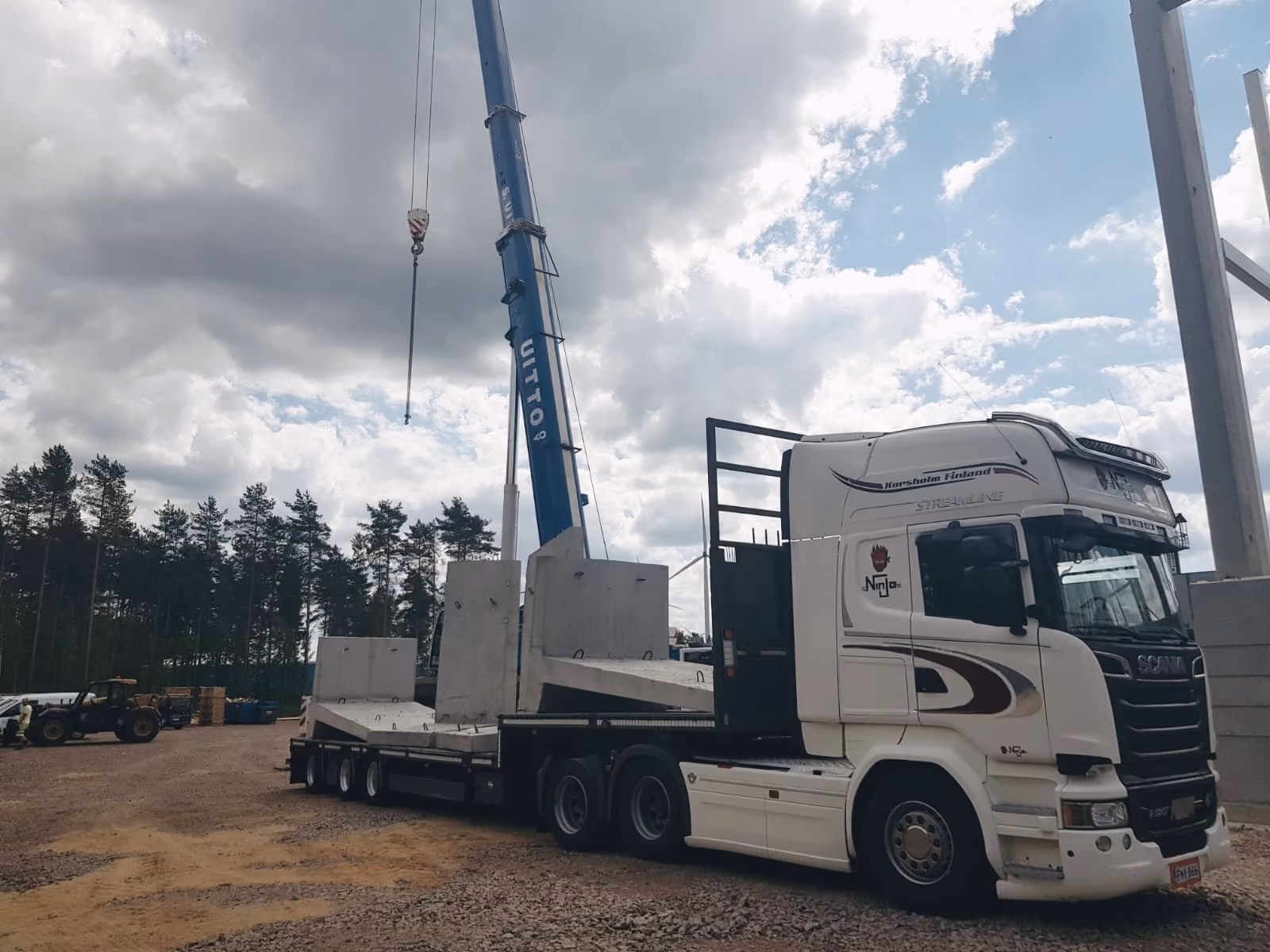 Lastbil lastad med entreprenadmaskin